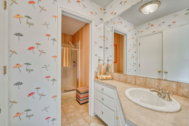 bathroom with tile patterned flooring, vanity, a textured ceiling, and a shower with door