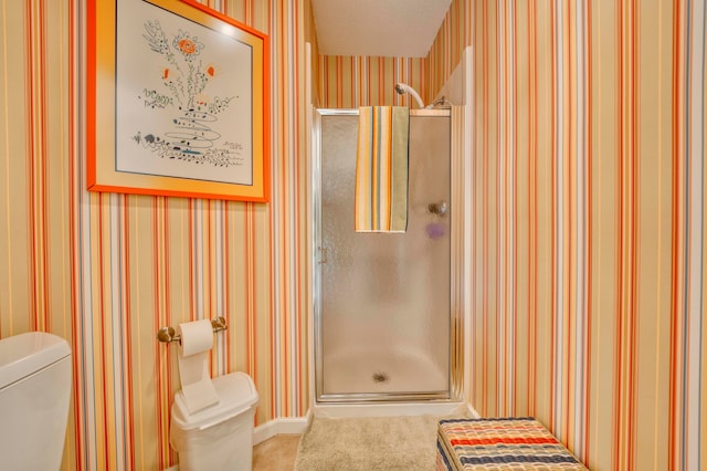 bathroom featuring a shower with door, a textured ceiling, and toilet