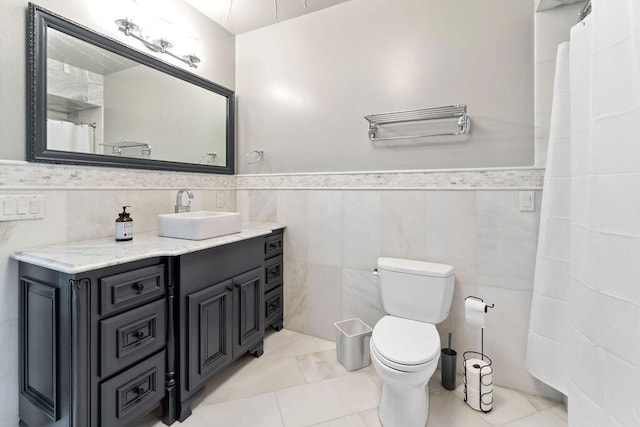 bathroom with tile walls, toilet, vanity, a shower with curtain, and tile patterned floors