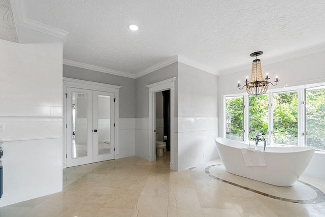 bathroom with a textured ceiling, toilet, and a bathing tub