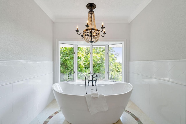 bathroom with ornamental molding, a textured ceiling, tile patterned floors, and a bath