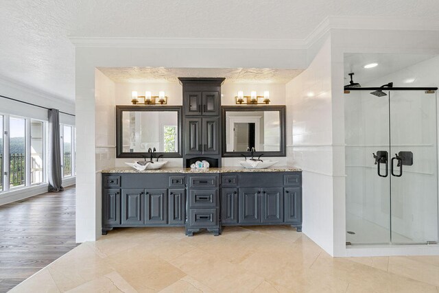 bathroom with hardwood / wood-style flooring, a shower with shower door, crown molding, vanity, and a textured ceiling