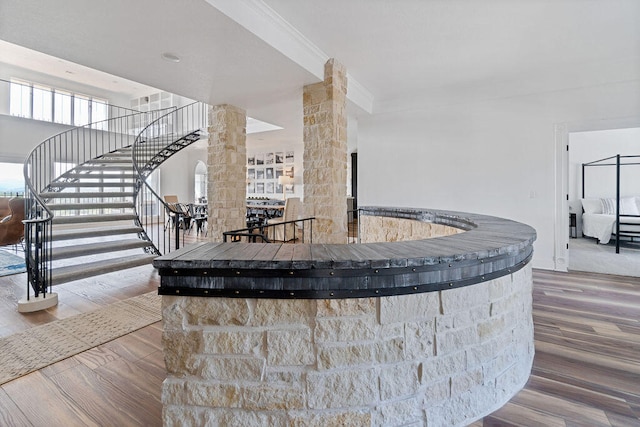 interior space with crown molding, hardwood / wood-style flooring, and decorative columns