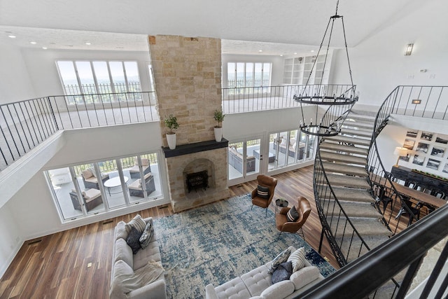 living room with a towering ceiling, hardwood / wood-style floors, and plenty of natural light