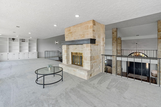 carpeted living room with a textured ceiling and a fireplace