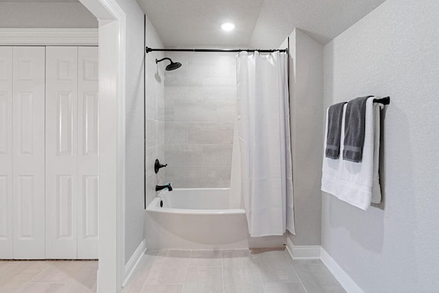 bathroom featuring tile patterned floors, shower / bathtub combination with curtain, and a textured ceiling