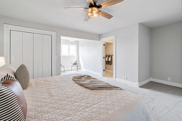 bedroom featuring a closet, a textured ceiling, carpet, and ceiling fan