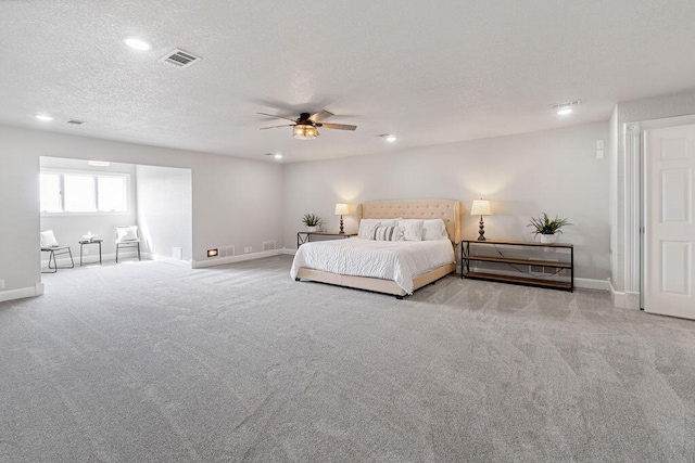 carpeted bedroom featuring a textured ceiling and ceiling fan