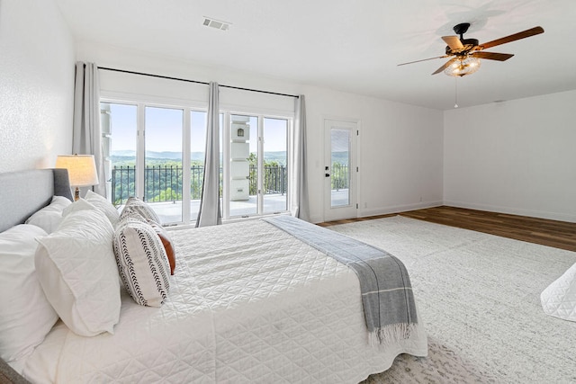 bedroom with ceiling fan, access to outside, and hardwood / wood-style floors