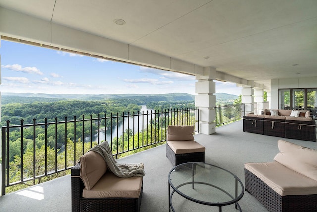 view of patio / terrace with a balcony, outdoor lounge area, and a water view