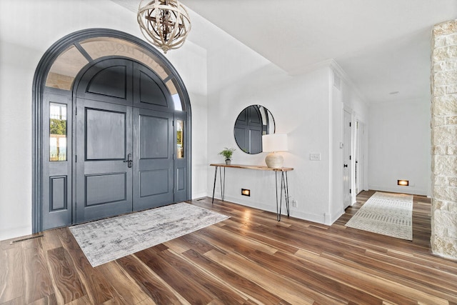 foyer entrance featuring dark wood-type flooring and a notable chandelier