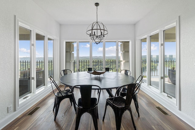 sunroom with a chandelier, a water view, and plenty of natural light