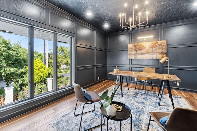 office area with an inviting chandelier, light hardwood / wood-style flooring, ornamental molding, and a healthy amount of sunlight