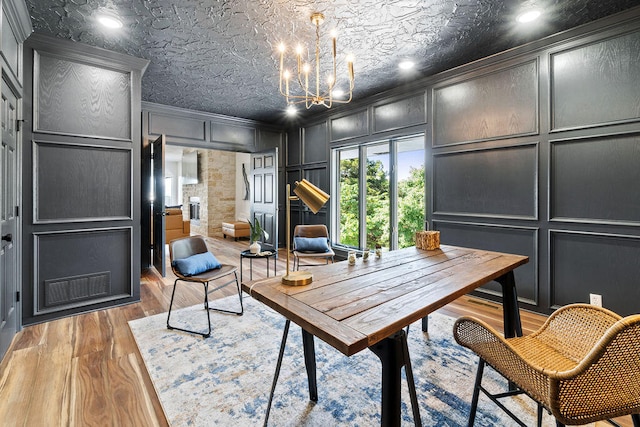 office featuring crown molding, a textured ceiling, wood-type flooring, and a chandelier