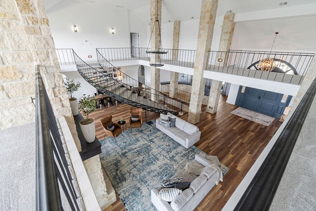 living room featuring a notable chandelier, high vaulted ceiling, and wood-type flooring