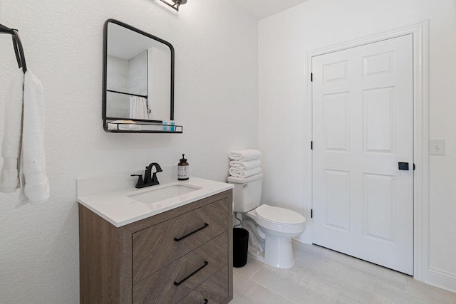 bathroom with vanity, toilet, and tile patterned flooring