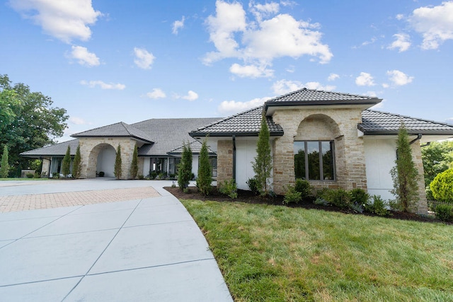 mediterranean / spanish house featuring a front lawn