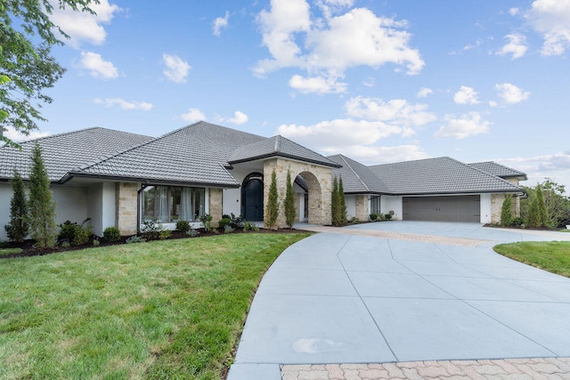 view of front of home with a front yard and a garage