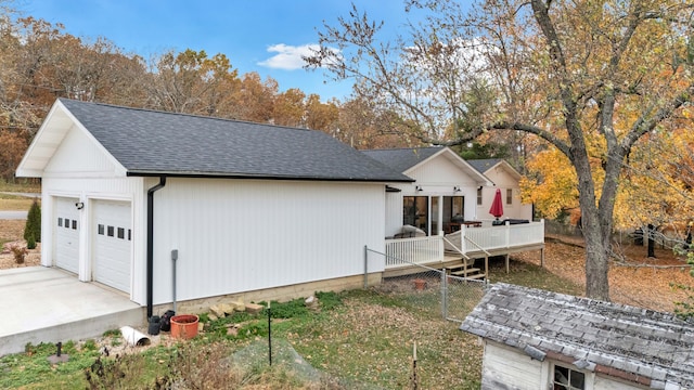 view of property exterior featuring a garage and a deck