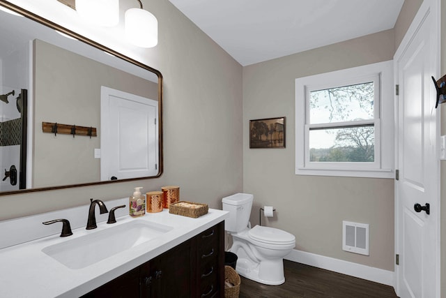 bathroom with heating unit, vanity, wood-type flooring, and toilet