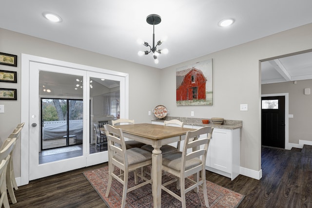 dining area featuring dark wood-type flooring and a chandelier