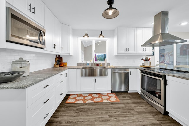 kitchen with appliances with stainless steel finishes, white cabinets, island range hood, and dark hardwood / wood-style floors