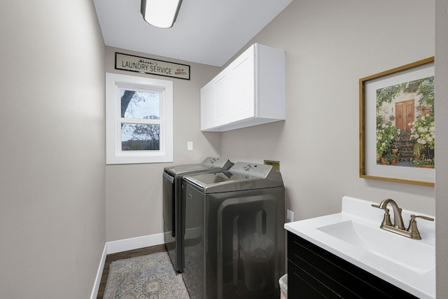 laundry room with cabinets, hardwood / wood-style floors, sink, and washer and clothes dryer