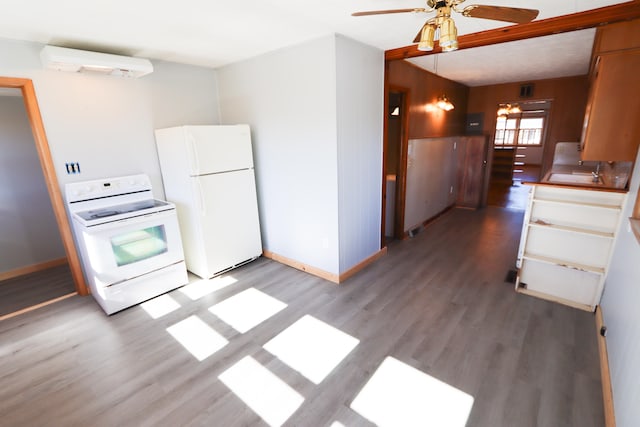 kitchen with a wall mounted air conditioner, hardwood / wood-style floors, ceiling fan, and white appliances