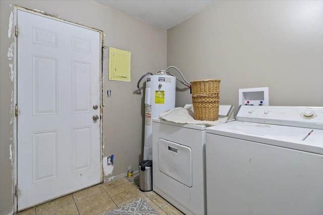 clothes washing area with electric water heater, light tile patterned flooring, and washing machine and clothes dryer