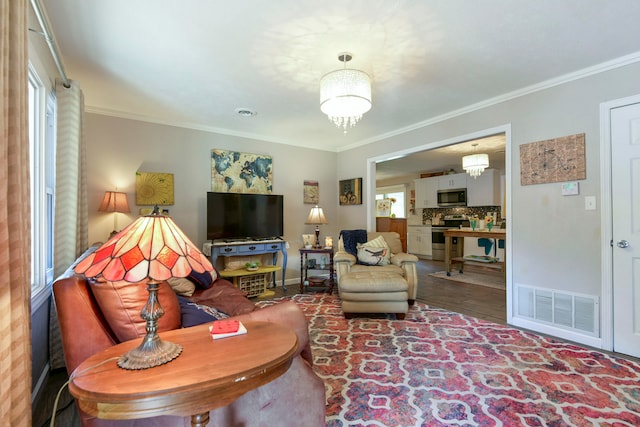 living room featuring hardwood / wood-style flooring, a healthy amount of sunlight, and crown molding