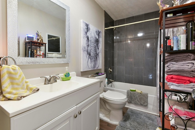 full bathroom featuring vanity, a textured ceiling, toilet, and tiled shower / bath