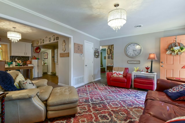 living room with ornamental molding and a chandelier