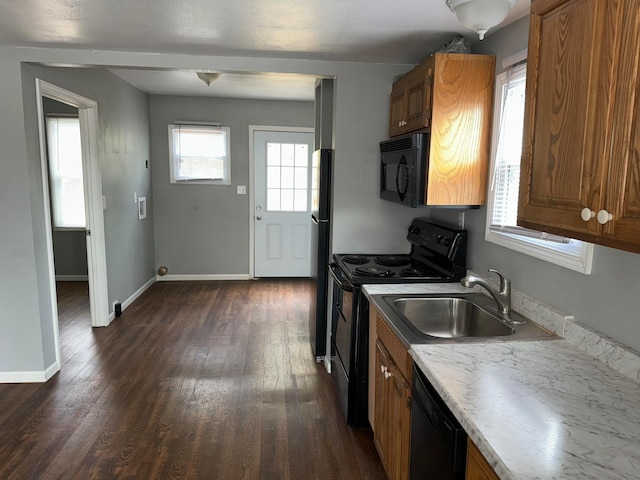 kitchen with black appliances, dark hardwood / wood-style flooring, and sink