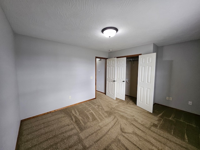 unfurnished bedroom featuring carpet, a textured ceiling, and a closet