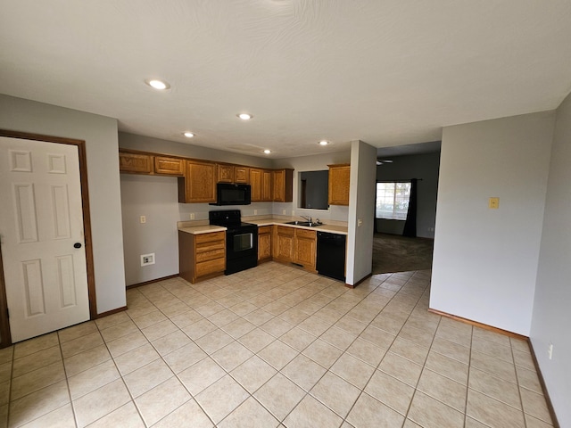 kitchen featuring black appliances, light tile patterned floors, and sink