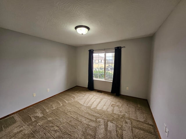 unfurnished room with a textured ceiling and light carpet