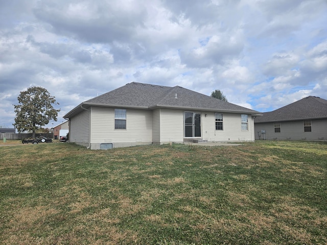 rear view of property featuring a lawn