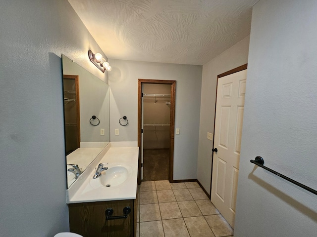 bathroom with tile patterned flooring, vanity, and a textured ceiling