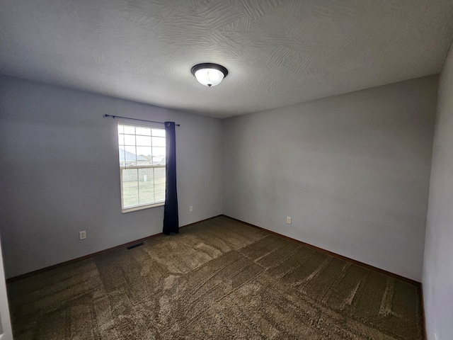 spare room with carpet and a textured ceiling