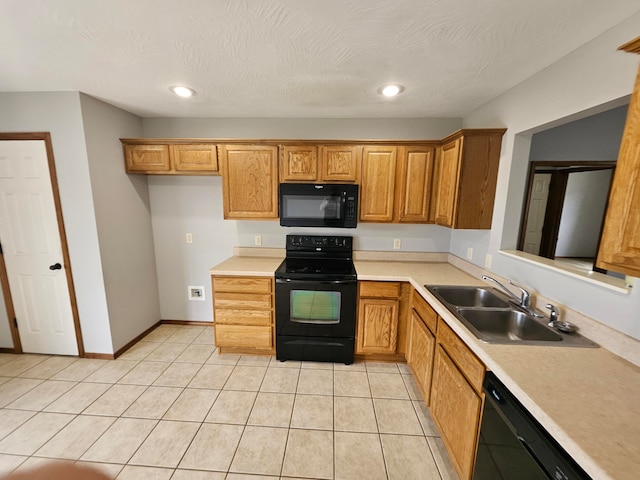 kitchen featuring sink, light tile patterned floors, black appliances, and a textured ceiling