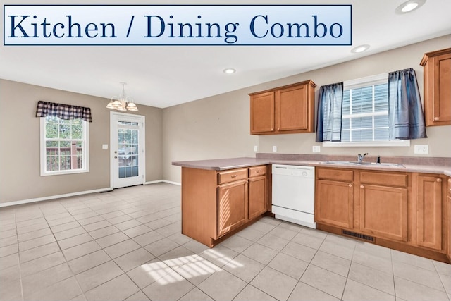 kitchen with light tile patterned flooring, kitchen peninsula, hanging light fixtures, a notable chandelier, and dishwasher