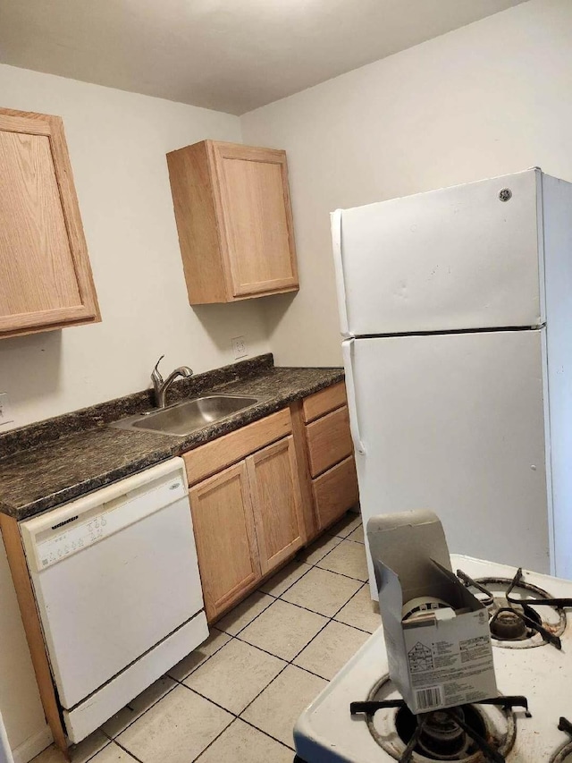 kitchen featuring light brown cabinetry, sink, light tile patterned floors, and white appliances