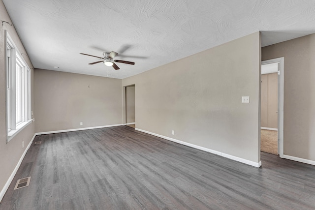 unfurnished room featuring a textured ceiling, dark hardwood / wood-style flooring, and ceiling fan