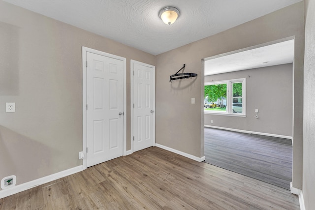 empty room featuring light hardwood / wood-style floors and a textured ceiling