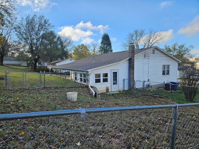 rear view of property with a lawn