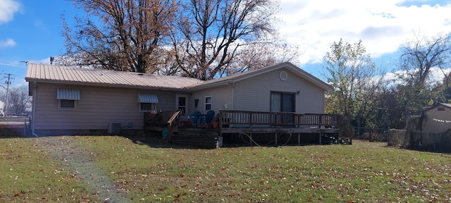 rear view of house featuring central AC unit, a yard, and a wooden deck