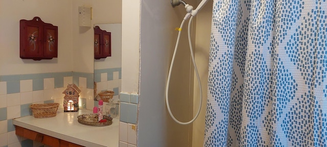 bathroom with a shower and tile walls