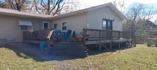 rear view of property with a deck and a yard