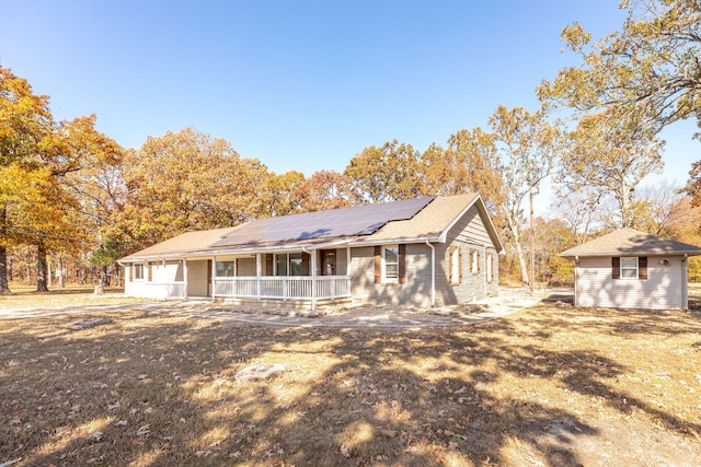 ranch-style house featuring solar panels and a wooden deck