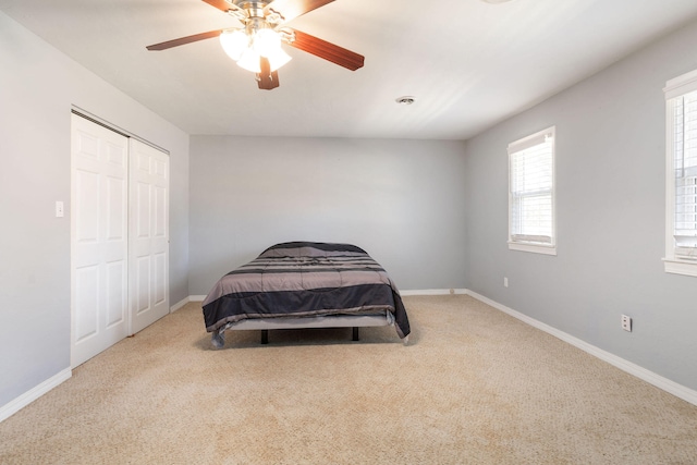 carpeted bedroom featuring a closet and ceiling fan